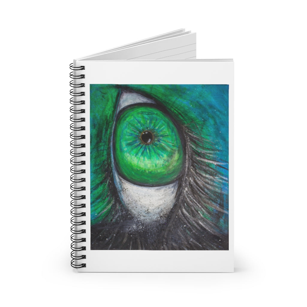 a spiral notebook with a drawing of a green alien eye.	