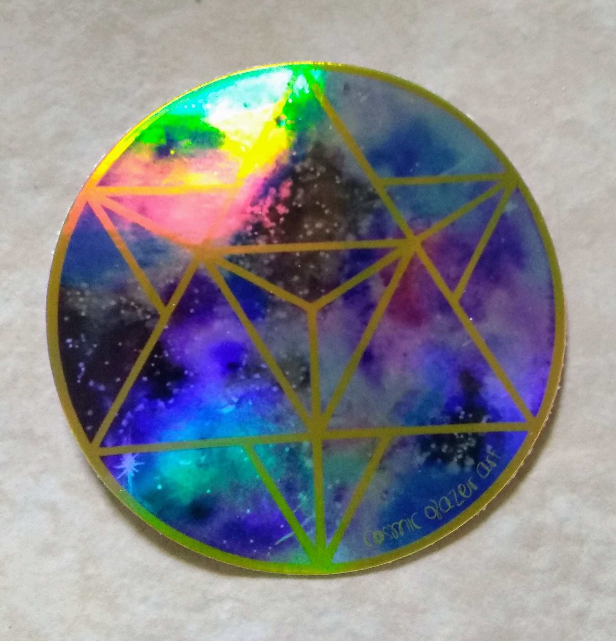 a picture of a rainbow holographic sticker with a geometric design.	