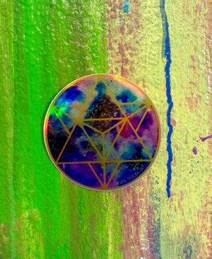 a picture of a rainbow holographic sticker with a geometric design on a colorful background.	