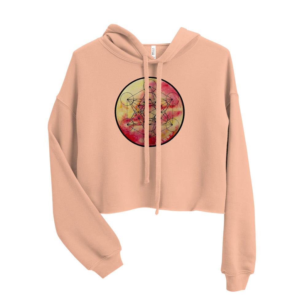 a cropped peach crop top hoodie with a metatrons cube design on the front.