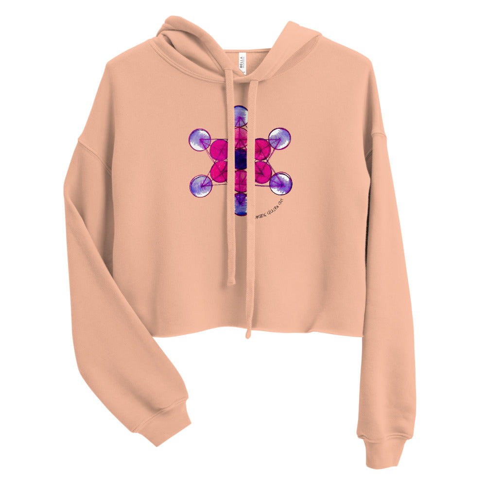 a peach crop top hoodie with a colorful geometric design on it.	